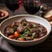 Une cocotte de bœuf bourguignon accompagnée d’un verre de vin rouge sur une table de cuisine.